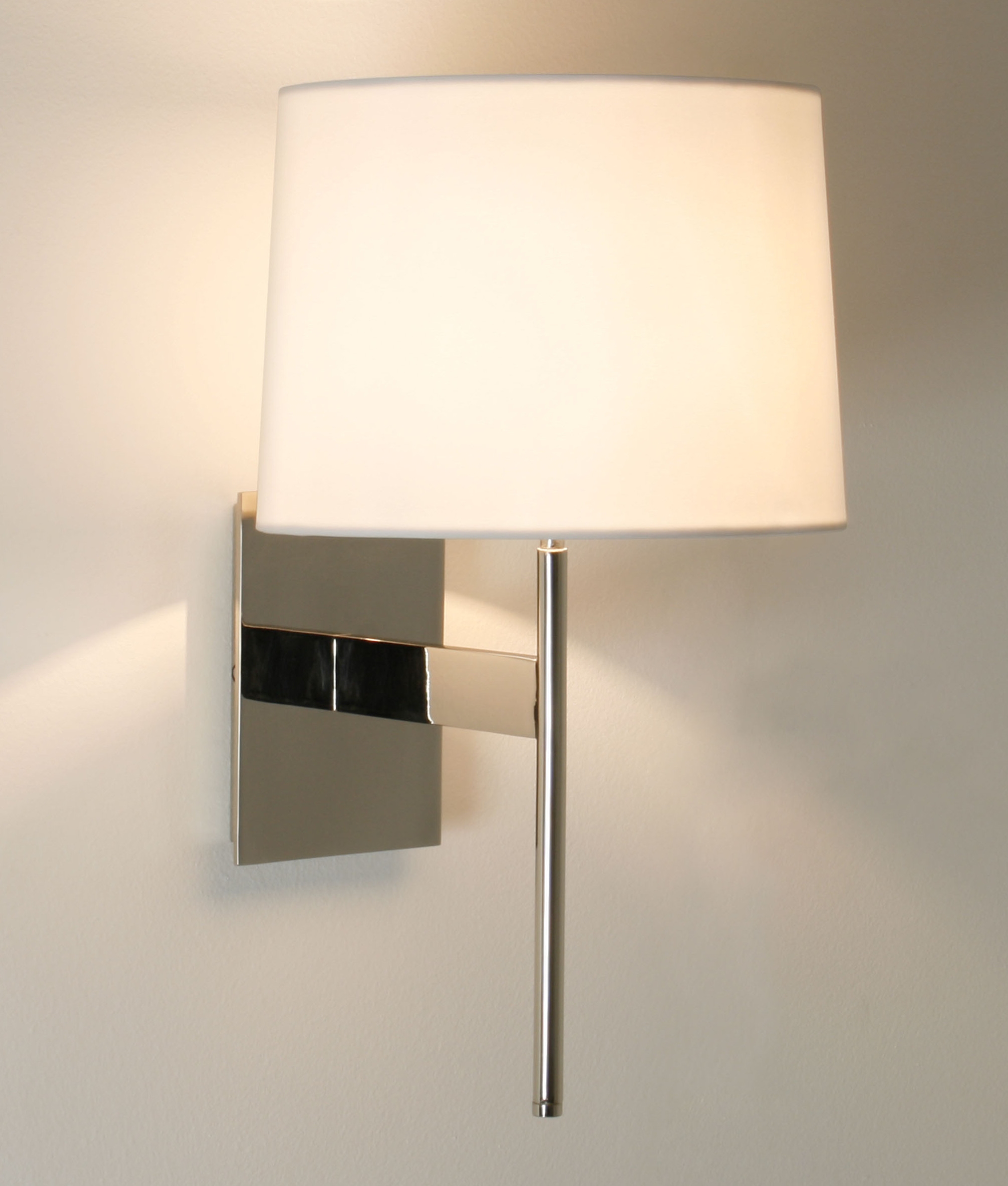 Elegant wall light with fabric shade is available in three finishes